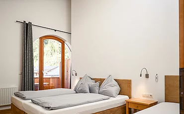 Ein gemütliches Bett im Family Haupthaus des Pechtlguts in Lofer