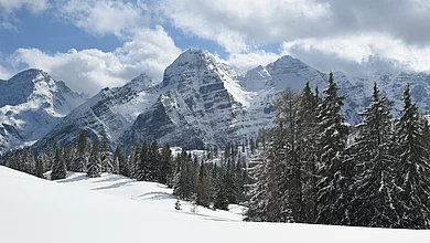 Eine verschneite Landschaft mit Berge im Hintergrund