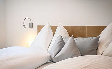 Ein gemütliches Bett im Family Haupthaus Plus des Pechtlguts in Lofer