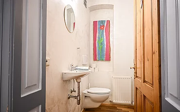 Das WC im Apartment Landhaus Garden mit einem bunten Bild auf der Wand im Pechtlgut in Lofer
