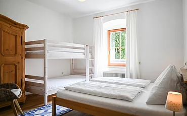 Ein Schlafzimmer mit einem Doppelbett und einem Stockbett im Apartment Landhaus Garden im Pechtlgut in Lofer