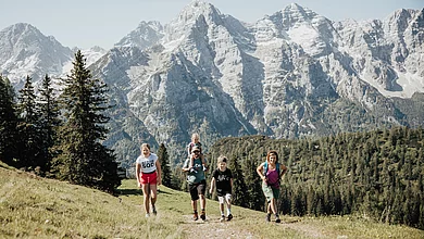 Eine Familie wandert auf einem Berg mit schöner Hintergrundkulisse