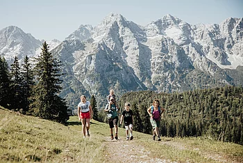 A family is hiking on a mountain with a beautiful backdrop
