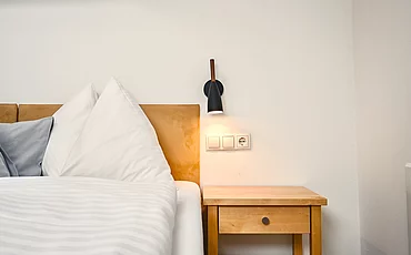 Ein gemütliches Bett im Family Haupthaus des Pechtlguts in Lofer