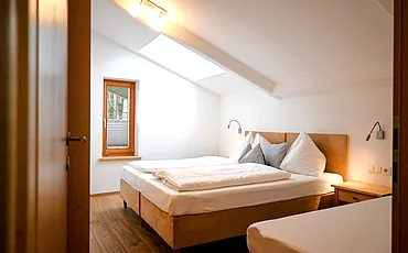 Ein gemütliches Bett im Family Haupthaus Plus des Pechtlguts in Lofer
