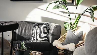Eine Ledercouch und ein Stuhl in der Lounge des Pechtlguts in Lofer