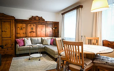 Die Couch vor stilvoller Holzverkleidung auf der Wand im Cottage Family des Pechtlguts in Lofer
