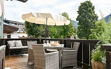 Der Balkon mit gemütlicher Sitzmöglichkeit des Apartments Landhaus Garden im Pechtlgut in Lofer